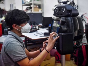 In this file photo taken on March 18, 2020 an engineering student configures a medical robot modified to screen and observe COVID-19 coronavirus patients at the Regional Center of Robotics Technology at Chulalongkorn University in Bangkok. "The coronavirus unexpectedly catapulted telework on a global scale, inaugurated mass telemedicine and introduced the world to the immense possibilities of new ways that technology can allow us to do from afar everything we thought only possible at close range. The impacts of artificial intelligence and remote monitoring of medical parameters will experience an irreversible boost," Karl Weiss and Ashley Weiss write.