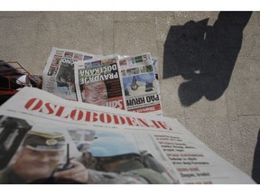 The silhouette of a Bosnian man reading a newspaper as others are around the stand in Sarajevo, Bosnia, May 27, 2011. During the siege of Sarajevo in the early 1990s, Sarajevans devoured Oslobođenje (Liberation) for news, "always hoping to find some glimmer of hope that the war was coming to an end," Emira Tufo writes, adding that its pages also served a second purpose.