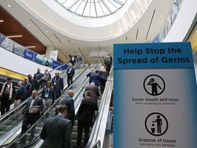 Visitors pass a sign warning about the spread of germs, after another case of the COVID-19 disease caused by the newly identified coronavirus was confirmed in the city, at the Prospectors and Developers Association of Canada (PDAC) annual conference in Toronto on Sunday, March 1, 2020.