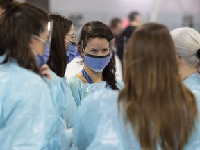 Medical staff prepare for the opening of the COVID-19 Assessment Centre at Brewer Park Arena in Ottawa, during a media tour on Friday, March 13, 2020. A Toronto hospital is accepting donations of face masks and other protective gear from members of the public in an effort to ward off what some say is an impending shortage.