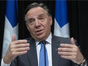 Premier François Legault responds to reporters at a news conference on the COVID-19 pandemic, Friday, March 27, 2020, at the legislature in Quebec City.