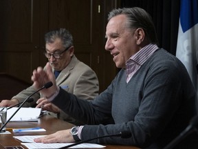 Quebec Premier Francois Legault speaks to reporters during a news conference on the COVID-19 pandemic, Sunday, March 29, 2020 at the legislature in Quebec City. Horacio Arruda, Quebec director of National Public Health, left, looks on.