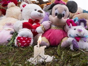 A candle burns amid stuffed animals outside the home of a seven-year-old Granby girl who was killed in May 2019.