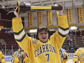 larkson's Elizabeth Giguère holds up the team's trophy after Clarkson defeated Colgate 2-1 in overtime in the NCAA college women's hockey Frozen Four championship game in Minneapolis on March 18, 2018.