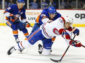 Canadiens' Max Domi is checked to the ice by Islanders defenceman Scott Mayfield during first-period action in Brooklyn Tuesday night.