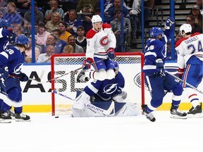 Montreal Canadiens centre Jake Evans (71) jumps as Tampa Bay Lightning goaltender Andrei Vasilevskiy (88) defends the puck  during the third period at Amalie Arena.