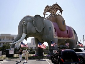 In this July 17, 2006, file photo, two women walk near Lucy The Elephant in Margate, N.J. The six-story National Historic Landmark is being offered up for overnight stays March 17-19 on the house-sharing website Airbnb for $138 a night. The promotion with Airbnb and the Save Lucy Committee is designed to encourage more visitors to the New Jersey shore and to the elephant, which is one of the oldest surviving roadside attractions in America.
