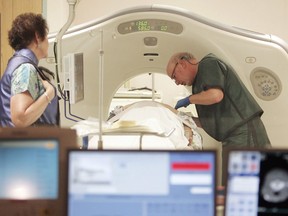 A physician works with a patient in a CT scanner. "Simulation studies suggest that if everyone eligible for lung cancer screening got yearly CT scans, you prevent just over 12,000 lung cancer deaths every year," Christopher Labos writes.