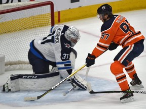 Edmonton Oilers captain Connor McDavid (97) scores on Winnipeg Jets goalie Connor Hellebuyck (37) during NHL action at Rogers Place in Edmonton, March 11, 2020. (Ed Kaiser/Postmedia)