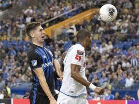 Impact defender Joel Waterman heads the ball away from C.D. Olimpia forward Jerry Bengtson during first-half action at Olympic Stadium Tuesday night.