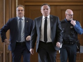 Quebec Premier François Legault, centre walks to a meeting with party leaders to discuss COVID-19 measures, Tuesday, March 17, 2020 at the legislature in Quebec City.