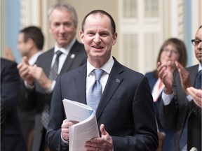 Finance Minister Éric Girard is applauded by members of the government as he stands to present his budget speech Tuesday in the National Assembly.