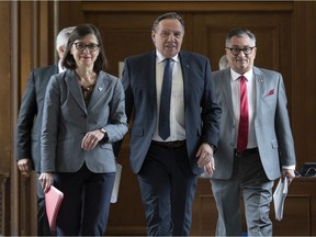 Quebec Premier Francois Legault, flanked by Quebec Health Minister Danielle McCann, let, and Horacio Arruda, Quebec director of National Public Health walk to a news conference on the COVID-19 situation, Tuesday, March 24, 2020 at the legislature in Quebec City.