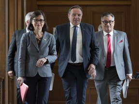 Quebec Premier François Legault, flanked by Quebec Health Minister Danielle McCann, left, and Horacio Arruda, Quebec director of public health, walk to a news conference on the COVID-19 situation, on Tuesday, March 24, 2020 at the National Assembly in Quebec City.