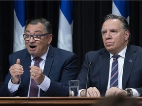Quebec national public health director Horacio Arruda responds to reporters questions as the government announces measures to contain the COVID-19 virus, Thursday, March 12, 2020 at the legislature in Quebec City. Quebec Premier Francois Legault, right, looks on.