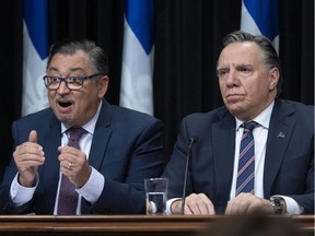 Quebec public health director Horacio Arruda responds to media questions Thursday, March 12, 2020 at the legislature in Quebec City. Quebec Premier François Legault, right, looks on.