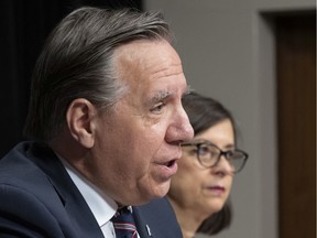 Premier Francois Legault announces measures to contain the COVID-19 virus, Thursday, March 12, 2020 at the legislature in Quebec City. Quebec Health Minister Danielle McCann, right, looks on.