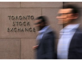 FILE PHOTO: Businessmen pass the Toronto Stock Exchange sing in Toronto, Ontario, Canada July 6, 2017.  REUTERS/Chris Helgren/File Photo