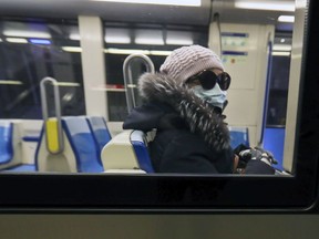 A woman wears a mask while riding in a near-empty métro car at Angrignon station.