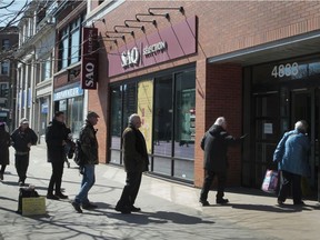 People line-up outside an SAQ location in  Westmount on March 21, 2020.