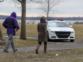 A police car patrols in Millennium Park in Dorval, west of Montreal Wednesday April 1, 2020. It's important for people in parks to stay at least two metres away from each other unless they are members of the same household.