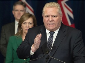 Ontario Premier Doug Ford answers questions as Health Minister Christine Elliott and Finance Minister Rod Phillips listen at Queen's Park in Toronto on Monday, March 23, 2020.