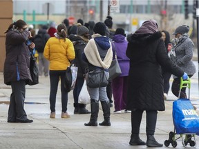 Shoppers line up to enter the Maxi grocery store in the LaSalle borough of Montreal on Friday, April 3, 2020.