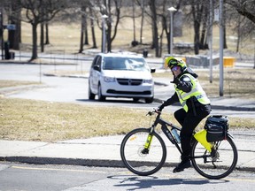 A police officer waves as she patrols Mount Royal Park in Montreal as the city deals with the coronavirus pandemic on April 6, 2020.