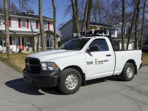 A truck from the Beaconsfield public works department drives up streets in the West Island suburb of Montreal broadcasting a social distancing reminder on April 6, 2020.