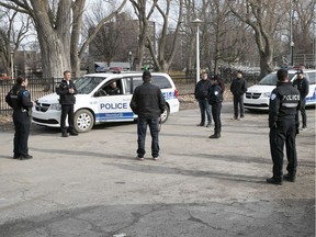 Montreal police practice social distancing while having an early morning meeting at Lafontaine Park before the start of their rounds on Wednesday April 8, 2020.
