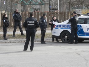 Montreal police practise social distancing while having an early morning meeting at Lafontaine Park before the start of their rounds on April 8, 2020.