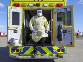 Urgences Santé's Joshua Arruda-Aguiar dons protective gear that paramedics wear on calls during the coronavirus crisis in Montreal Tuesday April 7, 2020. ( JOHN MAHONEY / Montreal Gazette)