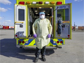Urgences Santé paramedic Joshua Arruda-Aguiar dons protective gear that paramedics must wear on calls during the coronavirus pandemic in Montreal.