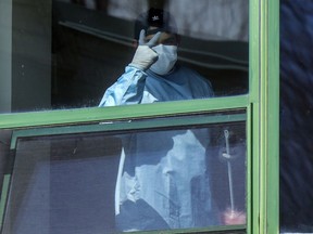 An employee at CHSLD Herron waves to a photographer in Dorval on Wednesday April 8, 2020. A Montreal Gazette investigation found unsanitary and unsafe conditions at the seniors' residence, where 31 people have died since beginning of the coronavirus pandemic.