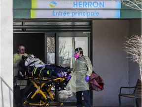 Paramedics wheel a resident out of CHSLD Herron in Dorval April 8, 2020.