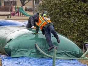 Contractors working for the city install flood barrier bladders on streets north of Gouin Blvd. in the Pierrefonds borough of Montreal Thursday April 9, 2020.