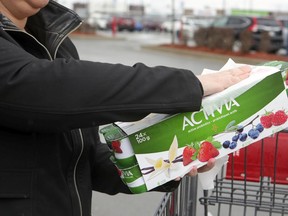 A woman who didn't want to be identified wipes down her purchases after shopping at the Costco in Vaudreuil-Dorion, west of Montreal, Friday April 10, 2020.