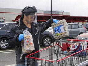 Si-Zhong Zhou wore an industrial face shield and rubber gloves to shop at the Costco in Pointe Claire, west of Montreal Friday April 10, 2020.