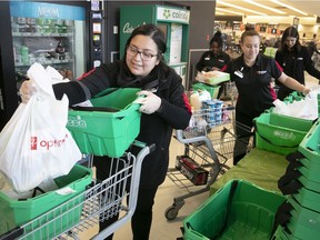 From left, Marta Colocho, Latisha Codougan, Lorraine Fyfe and Alyssa Maximov load up grocery bags for pickup at the Provigo on Sherbrooke and Cavendish April 10, 2020.