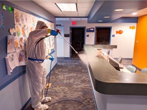 A Paul Davis Restoration Inc. employee disinfects a countertop at an undisclosed location.