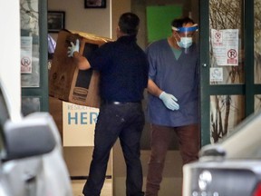 Men accept delivery of boxes at Residence Herron in Dorval, west of Montreal Monday April 13, 2020.