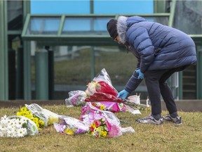 A woman leaves flowers outside Dorval’s Résidence Herron, where more than 30 people died from COVID-19, on April 13, 2020.