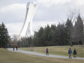 Olympic tower stands in the background as couples and individuals keep their social distancing, as they walk along Parc Maisonneuve on Wednesday April 15, 2020. (Pierre Obendrauf / MONTREAL GAZETTE) ORG XMIT: 64268 - 3786