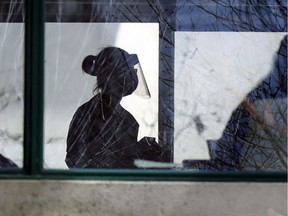 A worker in personal protective equipment walks through Residence Herron in Dorval, west of Montreal Wednesday April 15, 2020.