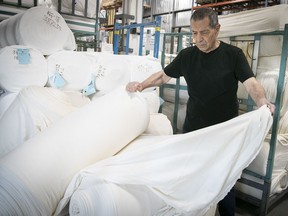 Owner and president Claude Helwani examines new textile manufactured at Tricots-Liesse in N.D.G.