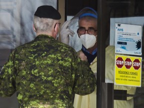 A Canadian Armed Forces member talks with a worker at a Laval seniors residence after meeting with staff there with other  Canadian military members in Laval near Montreal Sunday, April 19,2020. The military is deploying 125 medical workers in CHSLDs, hard hit by COVID-19.