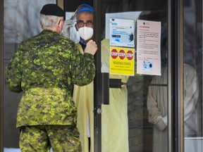 A Canadian Armed Forces member talks with a worker at a Laval seniors' residence on April 19, 2020.