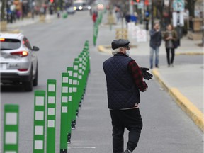 A man walks along a widened area of Monkland Ave. in N.D.G. April 19, 2020.  Montreal created a pedestrian zone to help accommodate physical distancing necessitated by the coronavirus crisis.