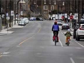 A cyclist and her daughter have most of Laurier Ave. in Montreal to themselves for a ride on April 27, 2020, during COVID-19 crisis.