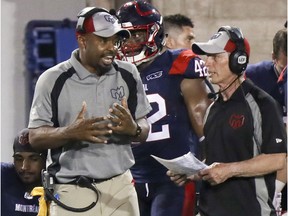 Alouettes head coach Khari Jones, left, has a conversation with defensive coordinator Bob Slowik  during CFL game against the  Hamilton Tiger-Cats at Molson Stadium last year.